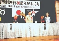盟約書に調印する両市長の画像